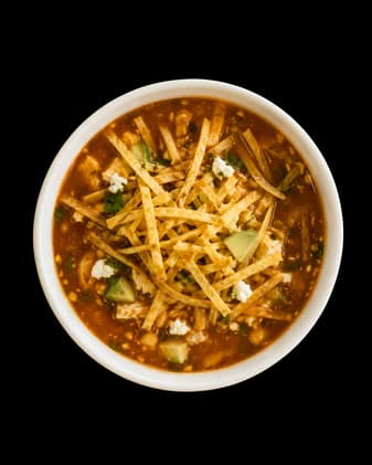 Chicken tortilla soup topped with crisp tortilla strips