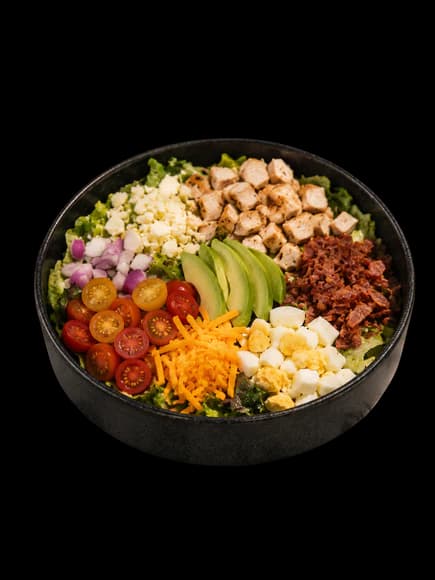 Cobb salad with grilled chicken, bacon, egg, avocado, tomatoes, and cheddar